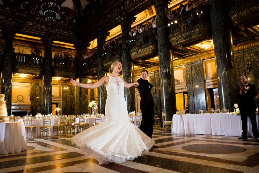 Bride and Groom having their first dance in grand ball room with wedding photographer