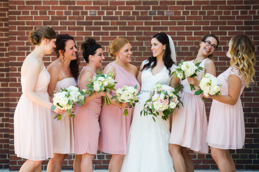 Bride and bridesmaids in mismatched light pink short dresses