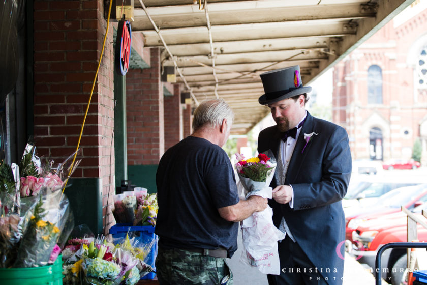 Groom in top hat buys flowers for his bride in the Strip District