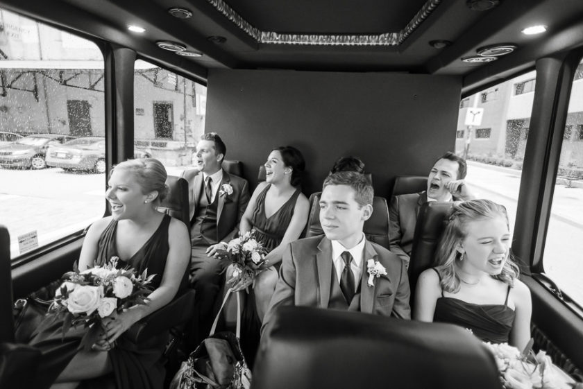 Bridal party singing in the rain on the shuttle van