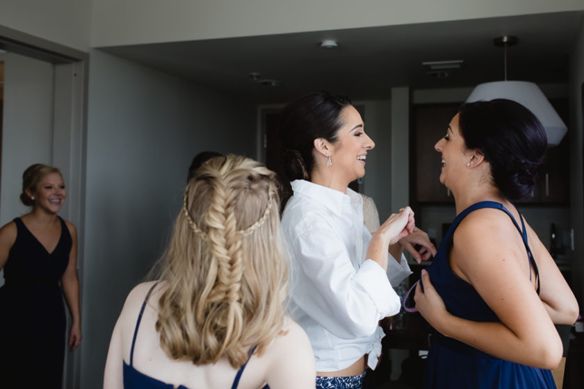 Bride and her sister laughing as they get ready