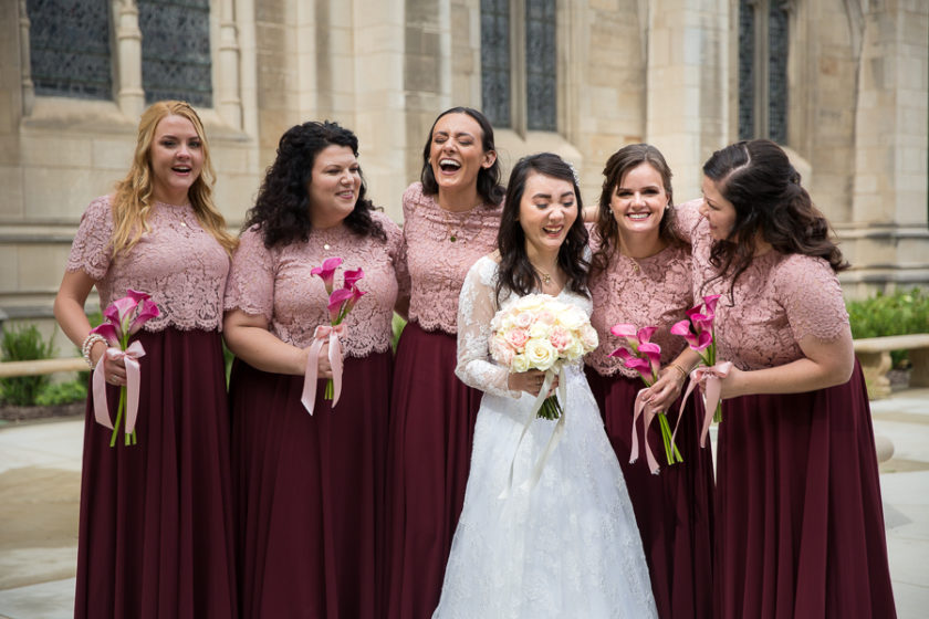 Bride and bridesmaids laughing in the garden outside Heinz Chapel