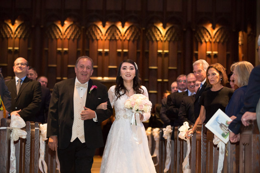 Bride and her dad walking down the aisle of her wedding ceremony