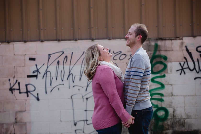 Engagement photos in front of graffiti wall in Pittsburgh's strip district