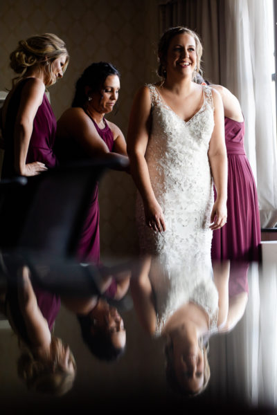 Bridesmaids buttoning Justin Alexander gown