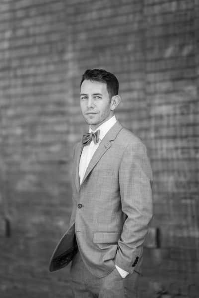 Groom with Bowtie in front of brick wall