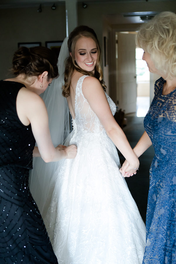 Bride's mother and sister helping her get dressed